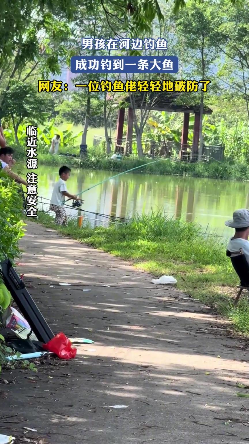 男孩在河邊釣魚，成功釣到一條大魚，一位釣魚佬輕輕地破防了