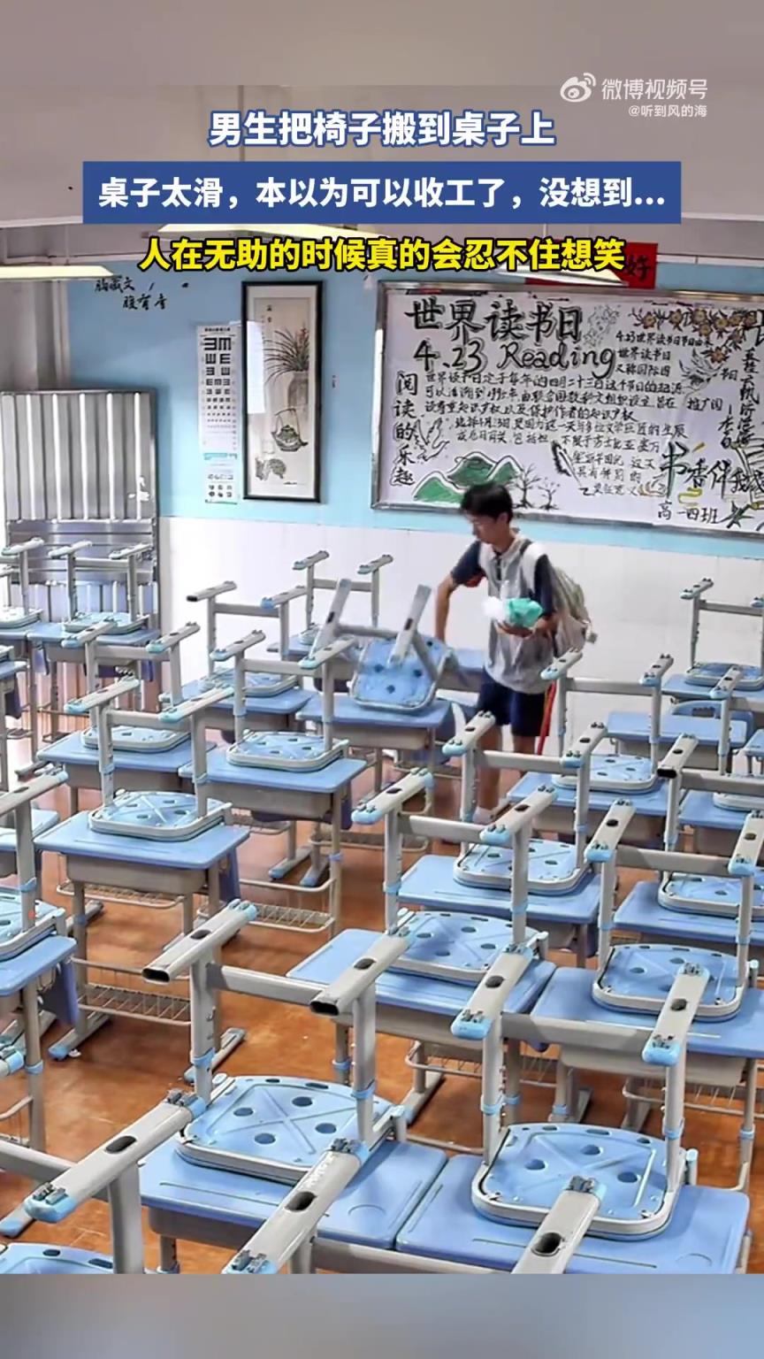 男生把椅子搬到桌子上