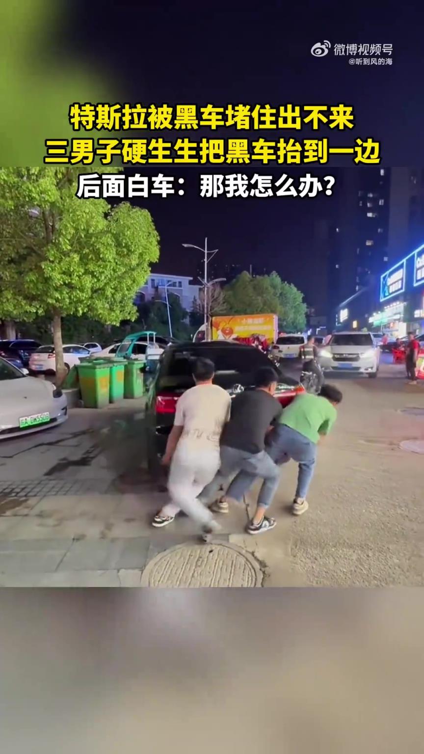 特斯拉被黑车堵住出不来，三男子硬生生把黑车抬到一边