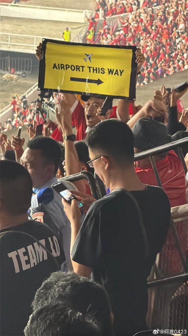 国足被淘汰后，现场有印尼球迷向中国球迷高举标语：机场走这边
