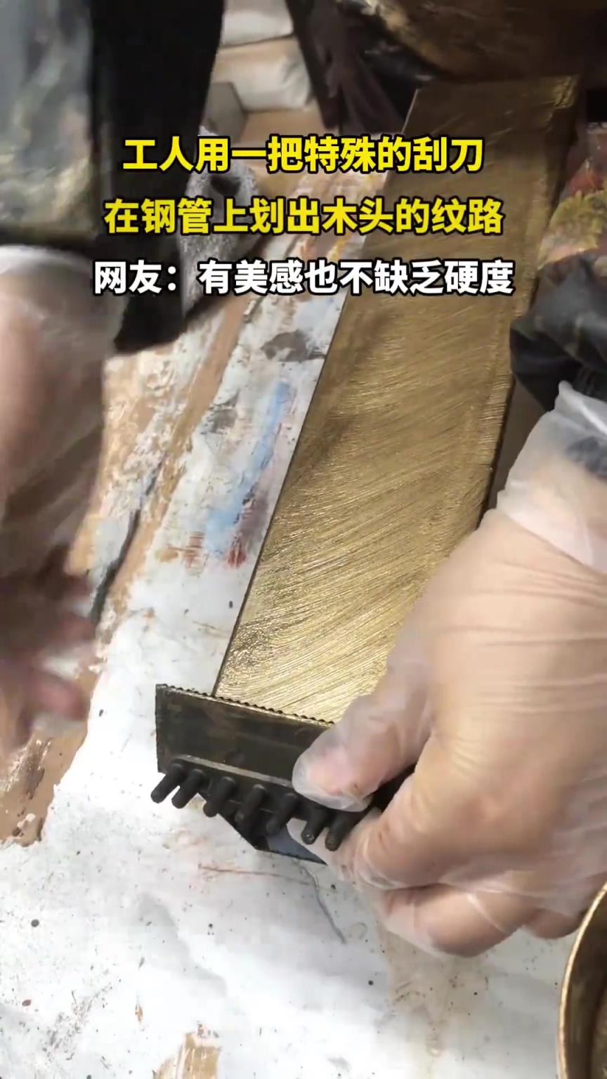 工人用一把特殊的刮刀，在钢管上画出木头的纹路