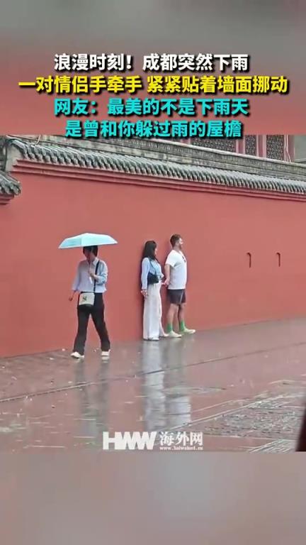 成都突然下雨 一对情侣手牵手紧紧贴着墙面挪动