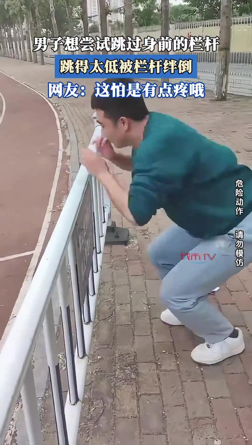 男子想尝试跳过身前的栏杆，跳得太低被栏杆绊倒