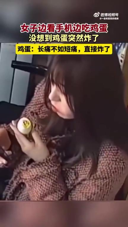 女子边看手机边吃鸡蛋，鸡蛋突然意外炸裂