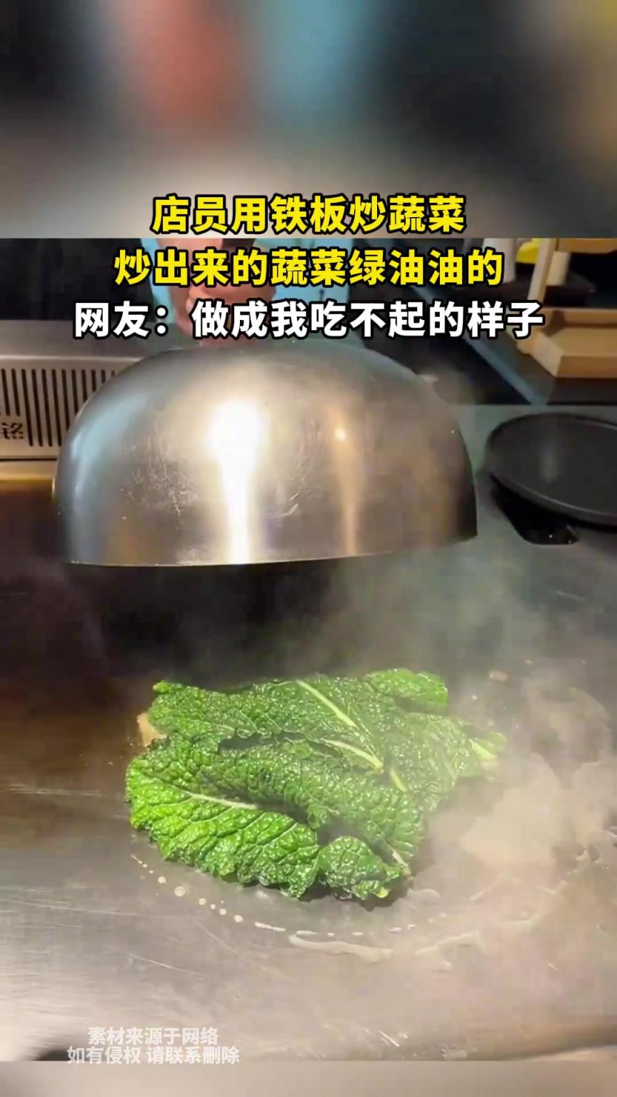 店员用铁板炒蔬菜，炒出来的蔬菜绿油油的