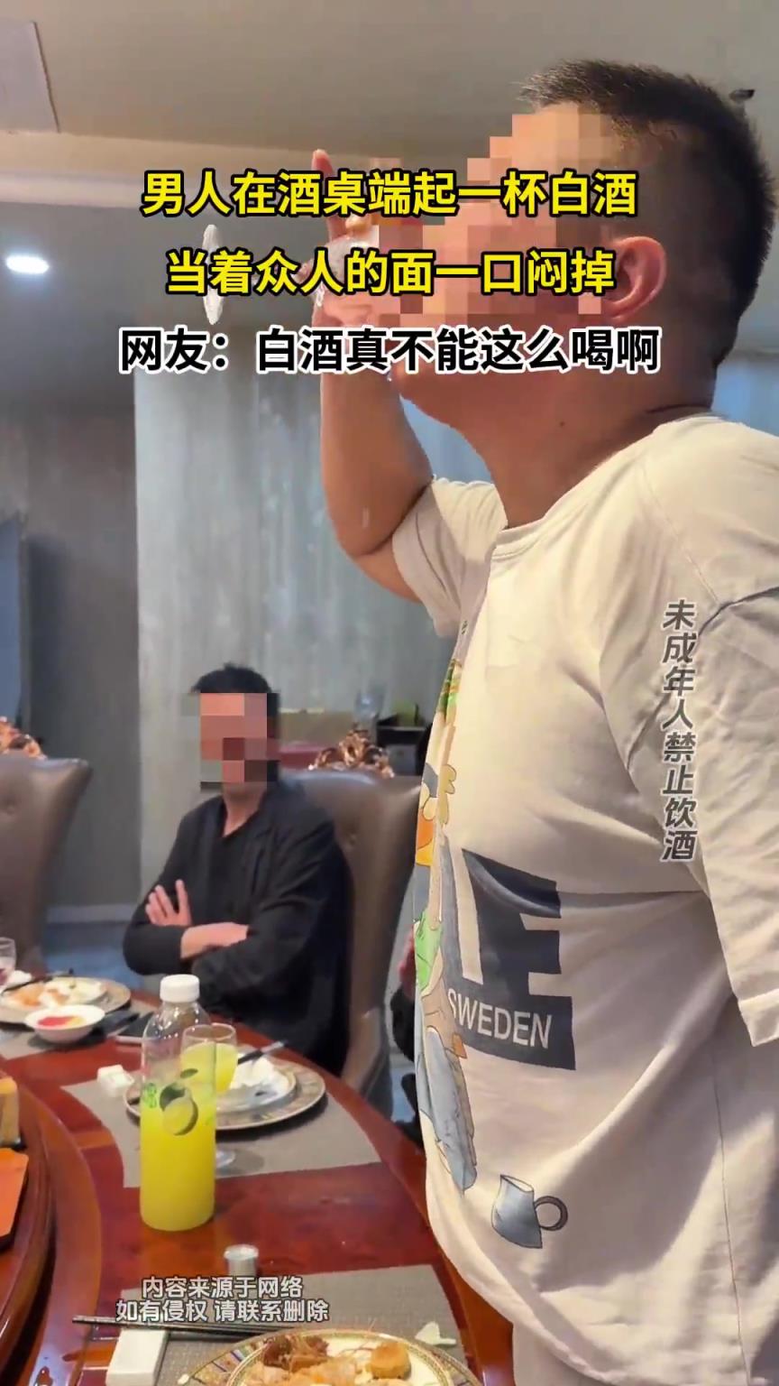男人在酒桌端起一杯白酒，当着众人的面一口闷掉