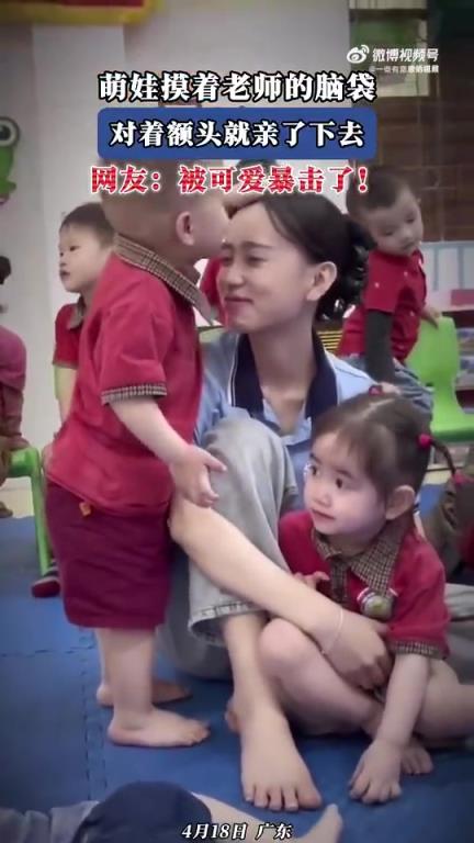 萌娃摸老師腦袋，對(duì)著額頭甜蜜一親，可愛(ài)爆棚