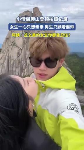 小情侶爬山登頂拍照記錄，女生一心只想親親男生只顧著耍帥