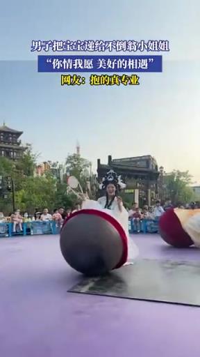 男子递宝宝给不倒翁小姐姐，画面超有爱