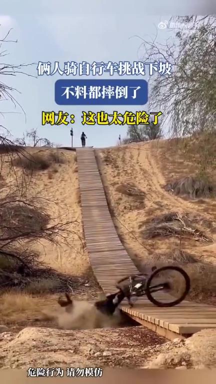 俩人骑自行车挑战下坡，不慎双双摔倒