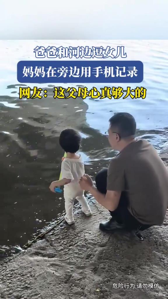 爸爸和河边逗女儿，妈妈在旁边用手机记录