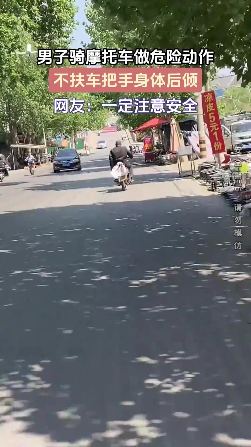 男子骑摩托车做危险动作，不扶车把手身体后倾