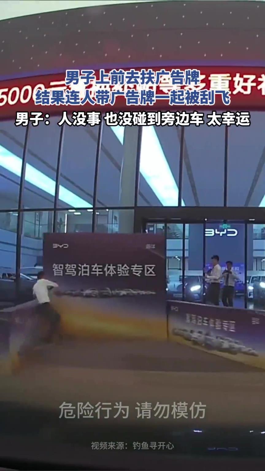 男子上前去扶广告牌，结果连人带广告牌一起被刮飞！！！