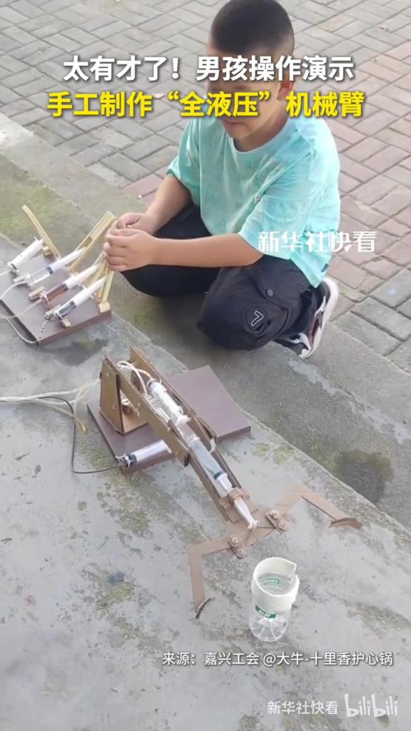 男孩操作演示手工制作“全液压”机械臂