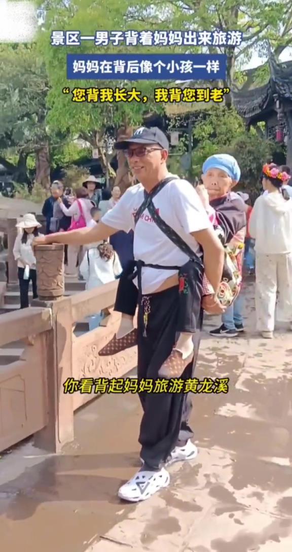 景区一男子背着妈妈出来旅游,妈妈在后面像个孩子!