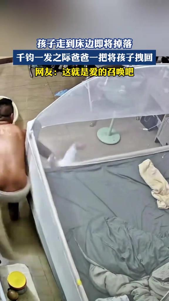 孩子走到床边即将掉落，千钧一发之际爸爸一把将孩子拽回