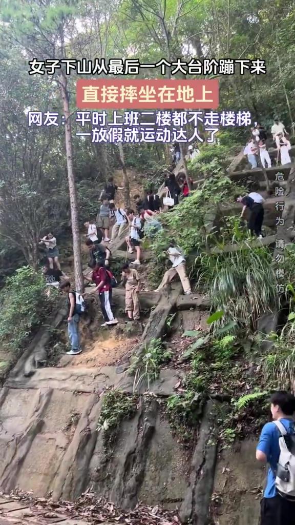 女子下山从最后一个大台阶蹦下来 直接摔倒 坐在地上