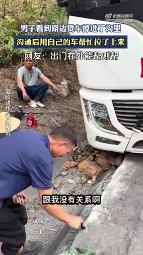男子看到路边货车掉进了沟里，沟通后用自己的车帮忙拉了上来。