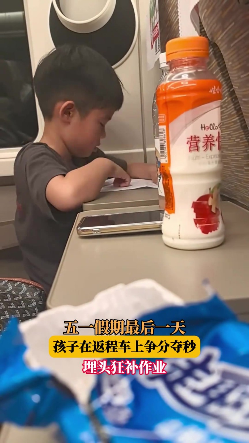 五一假期最后一天，孩子在返程車上爭(zhēng)分奪秒，埋頭狂補(bǔ)作業(yè)