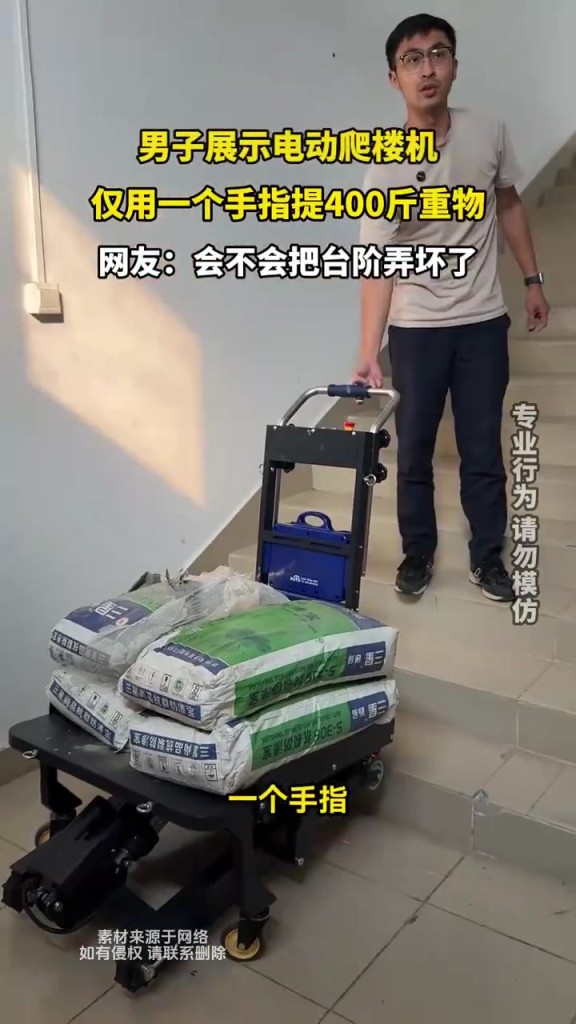 男子展示電動爬樓機(jī) 僅用一個手指提400斤重物