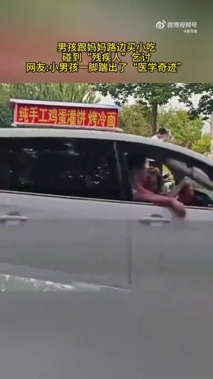 男孩與媽媽路邊買小吃時(shí)遇“殘疾人”乞討