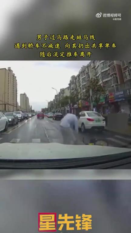 男子過馬路遇轎車不減速，怒扔共享單車后淡定推車