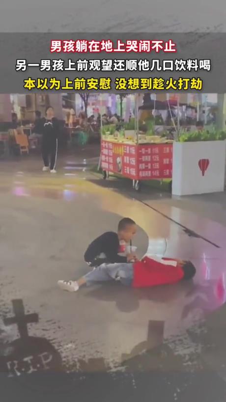 男孩躺在地上哭闹不止，另一个小男孩上前趁火打劫