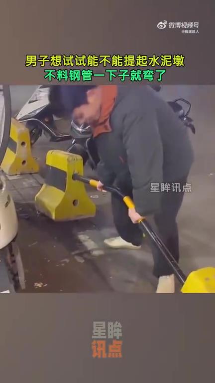 男子尝试提起水泥墩，钢管瞬间弯曲