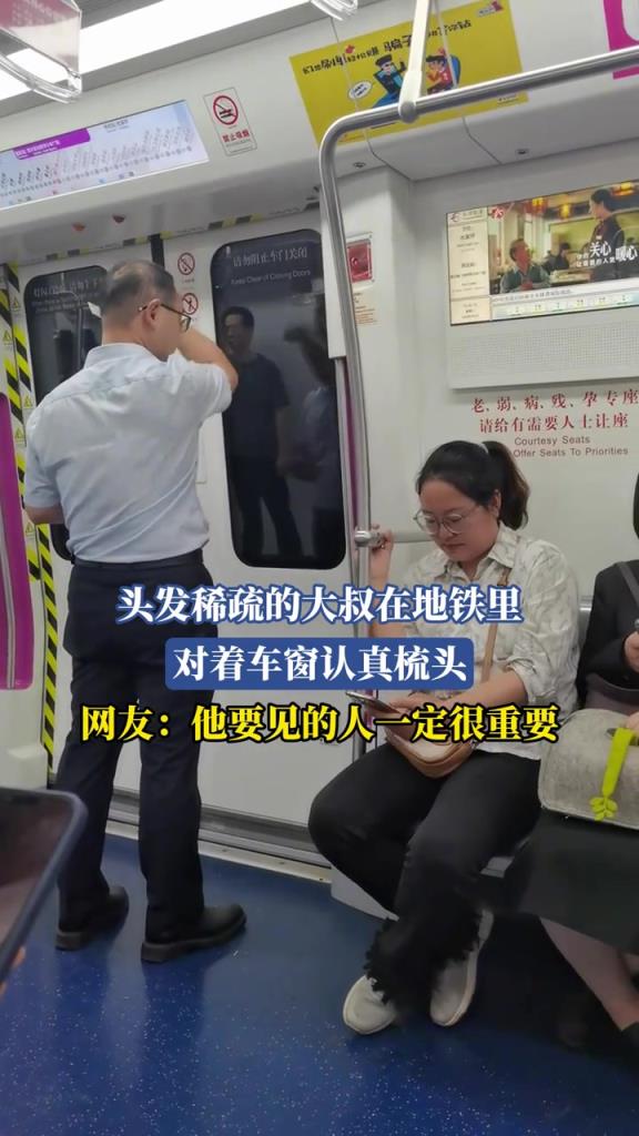 頭發(fā)稀疏的大叔在地鐵里 對(duì)著車(chē)窗認(rèn)真梳頭