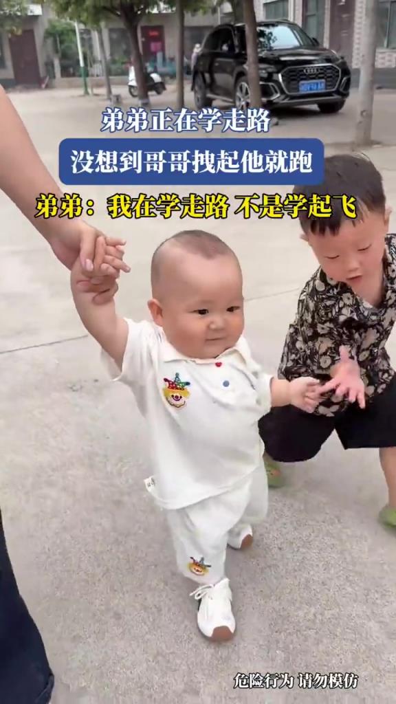 弟弟正在學(xué)走路，沒想到哥哥拽起他就跑