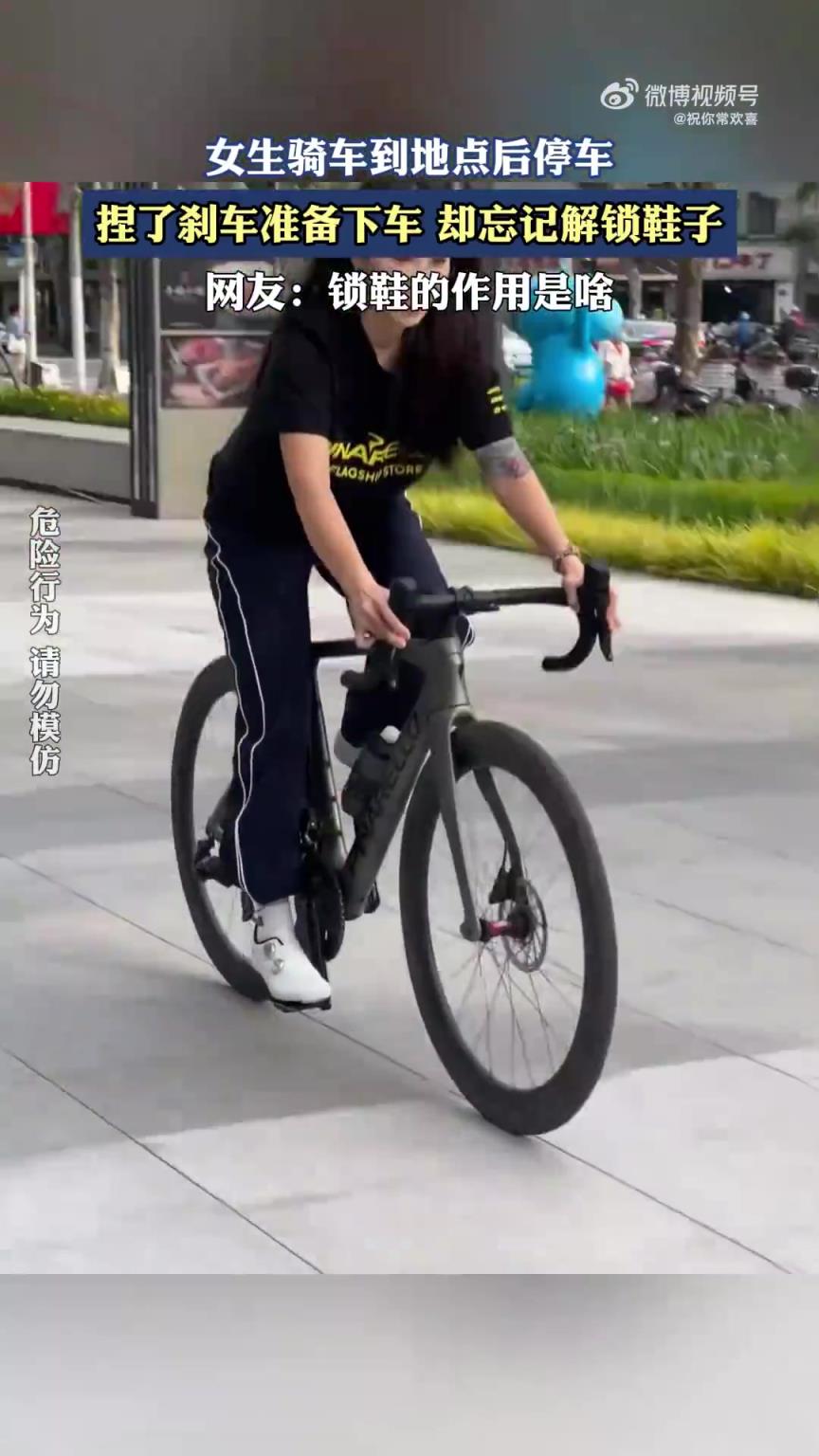 女生骑车抵达停车处，捏刹车欲下车时忘解锁鞋子
