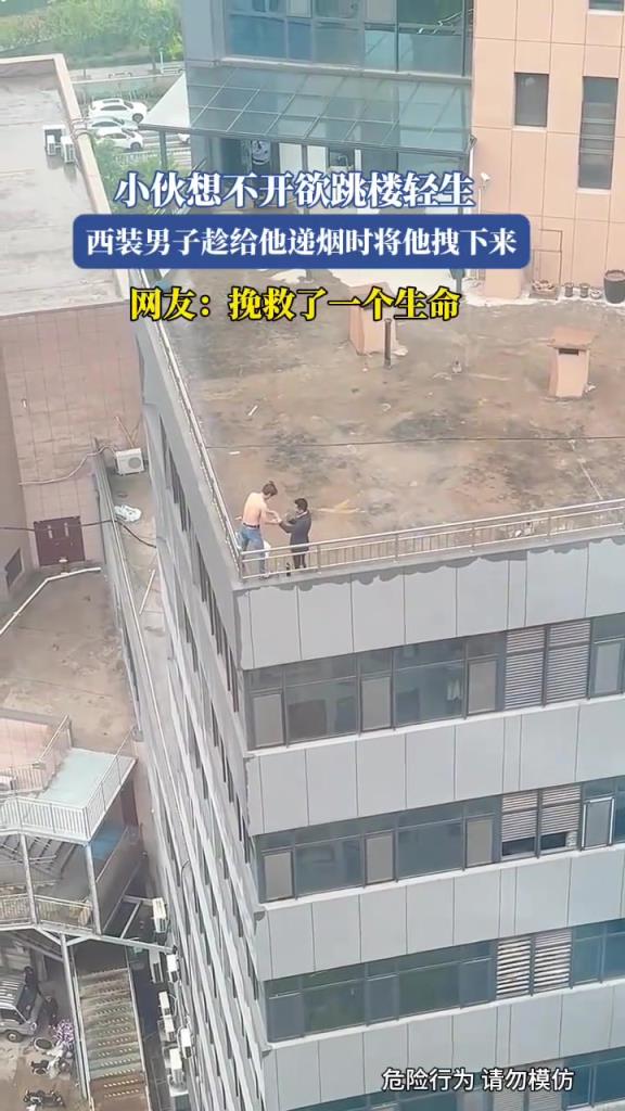 小伙想不开欲跳楼轻生，西装男子趁给他递烟时将他拽下来