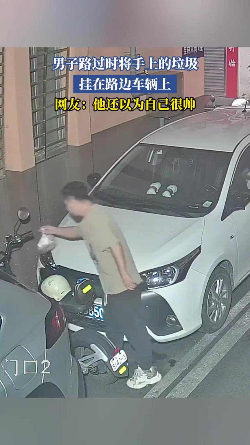 男子路過時將手上的垃圾掛在路邊車輛上！太沒素質(zhì)了！