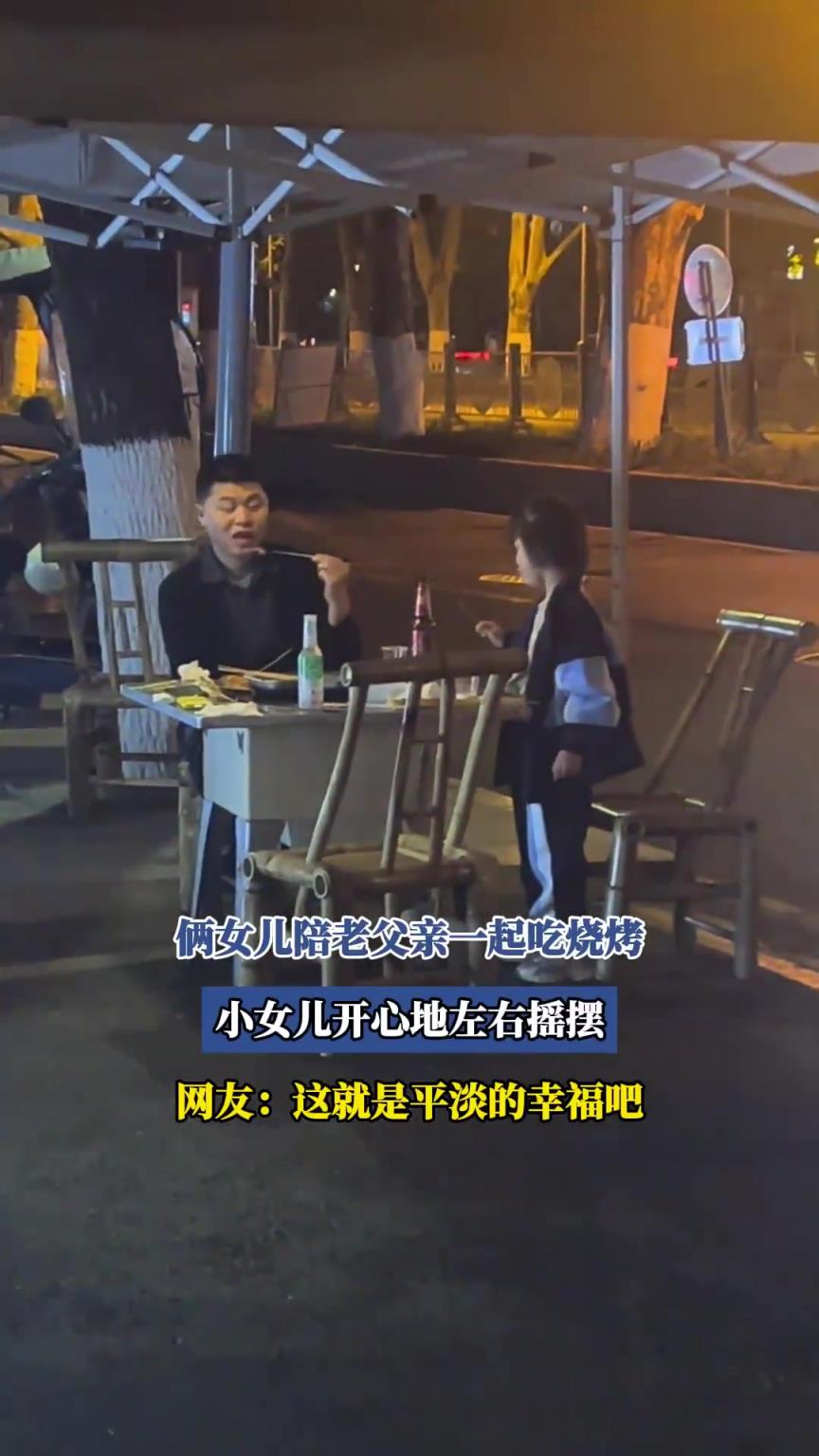 倆女兒陪老父親一起吃燒烤，小女兒開(kāi)心地左右搖擺！！
