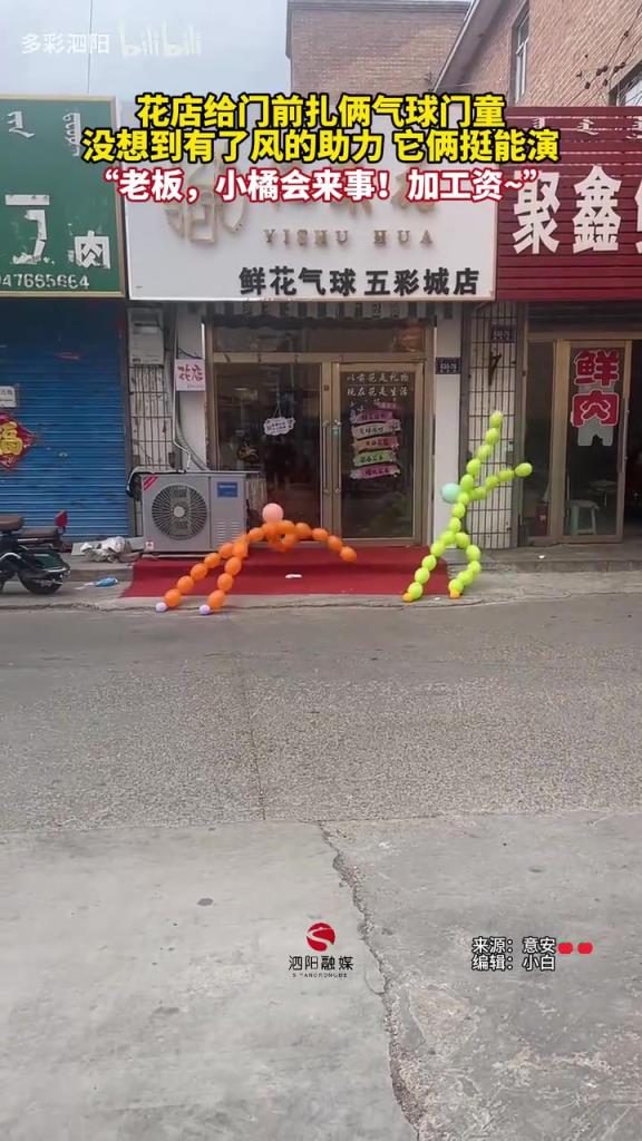 花店給門前扎倆氣球門童，沒想到有了風的助力 它倆挺能演