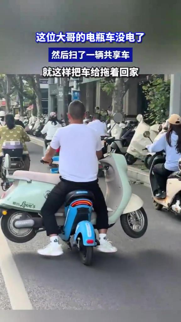 这位大哥的电瓶车没电了 然后扫了一辆共享车 把车给拖着回家