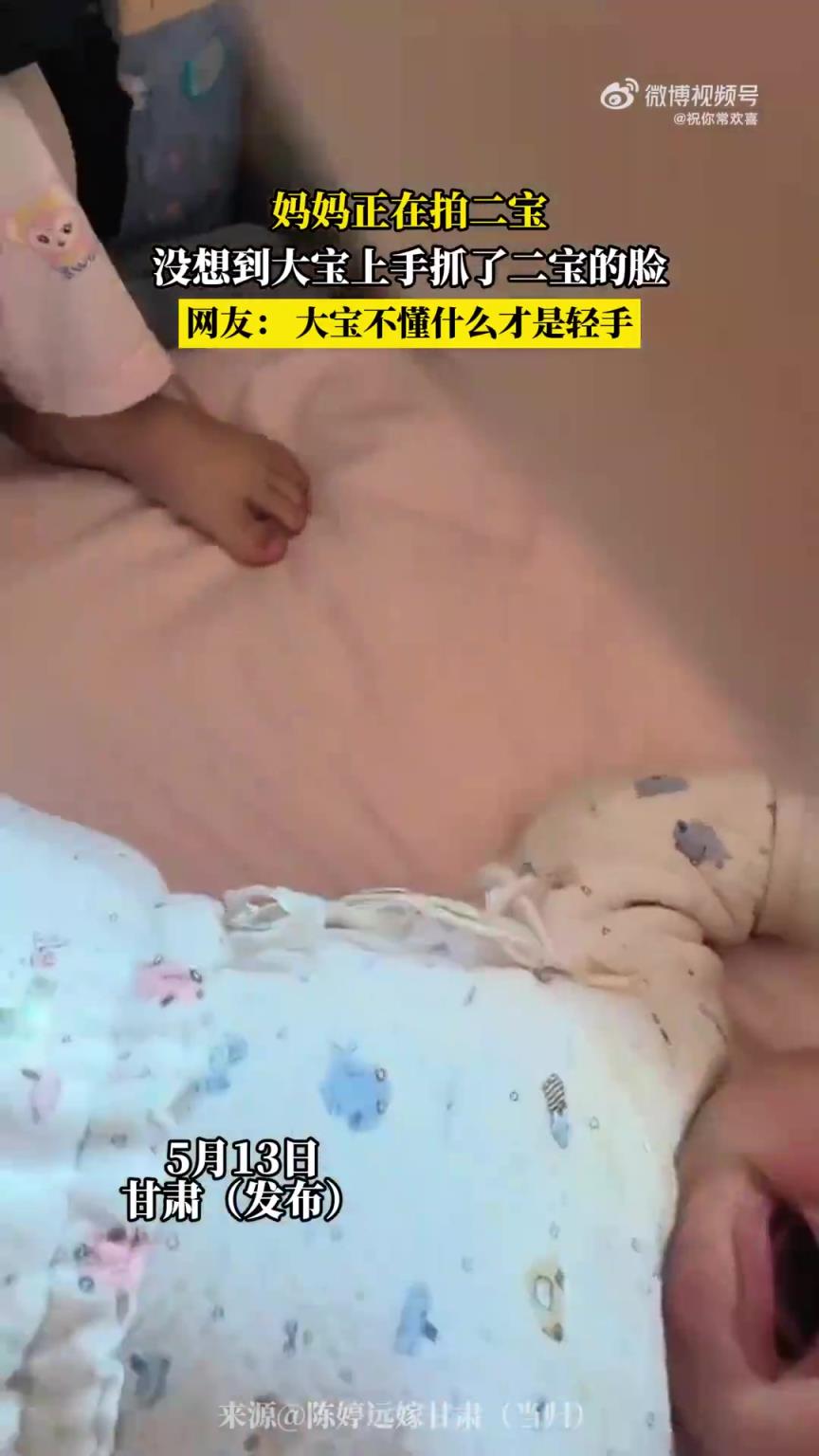 妈妈拍二宝时，大宝突然上手抓二宝的脸