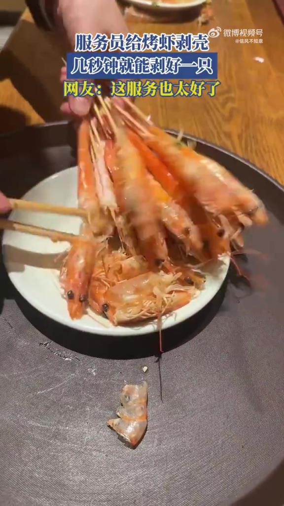 服务员给烤虾剥壳，几秒钟就能剥好一只