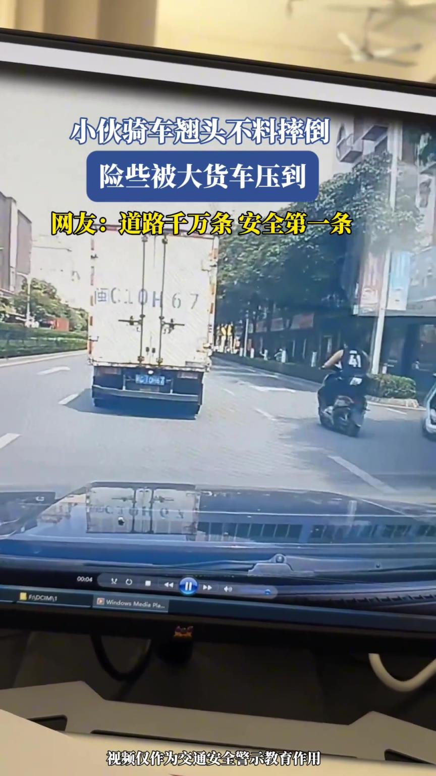 小伙騎車(chē)翹頭不料摔倒，險(xiǎn)些被大貨車(chē)壓到