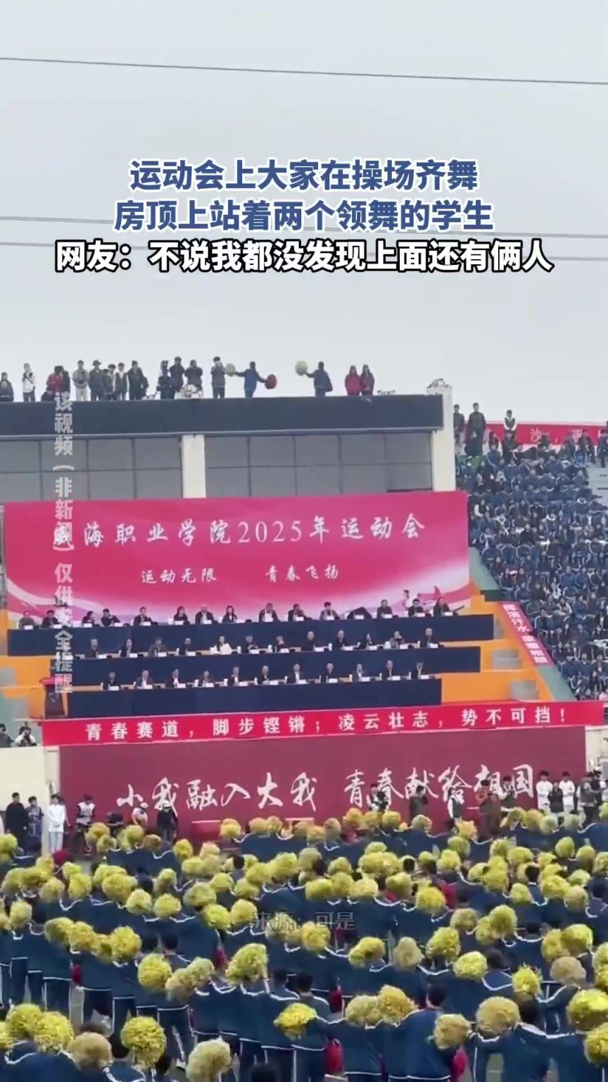 運(yùn)動(dòng)會(huì)上大家在操場(chǎng)齊舞，房頂上站著兩個(gè)領(lǐng)舞的學(xué)生！！