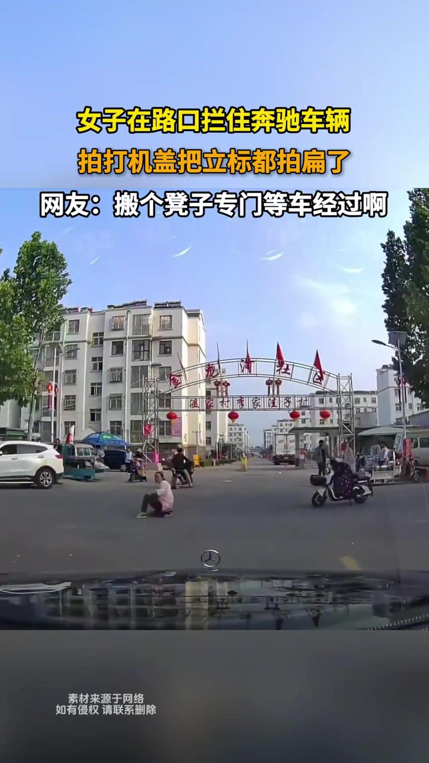 女子在路口拦住奔驰车辆，拍打机盖把立标都拍扁了