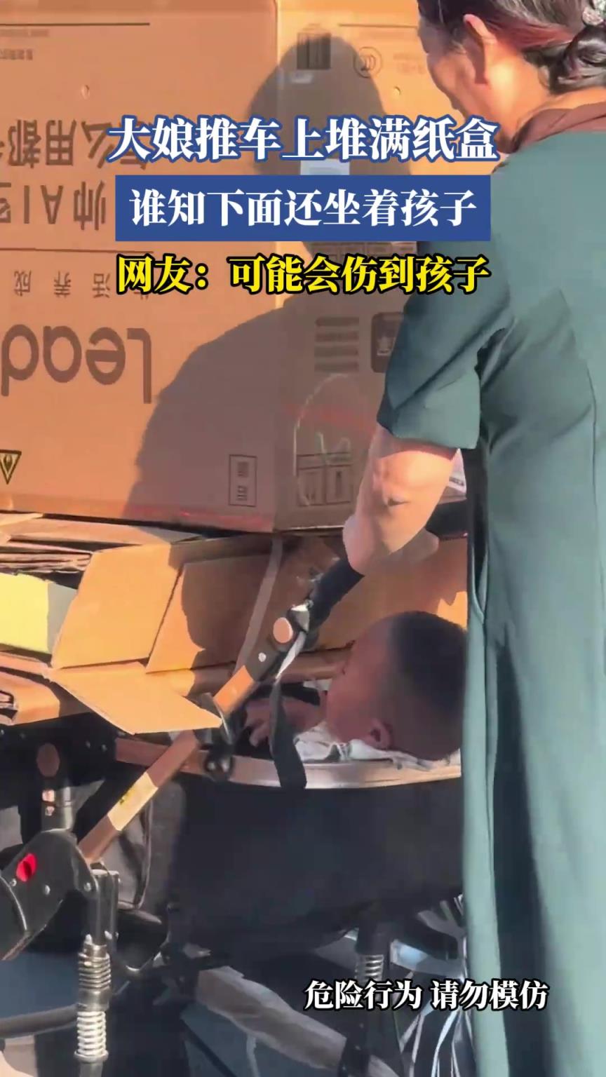 大娘推车上堆满纸盒，谁知下面还坐着孩子，网友：可能会伤到孩子