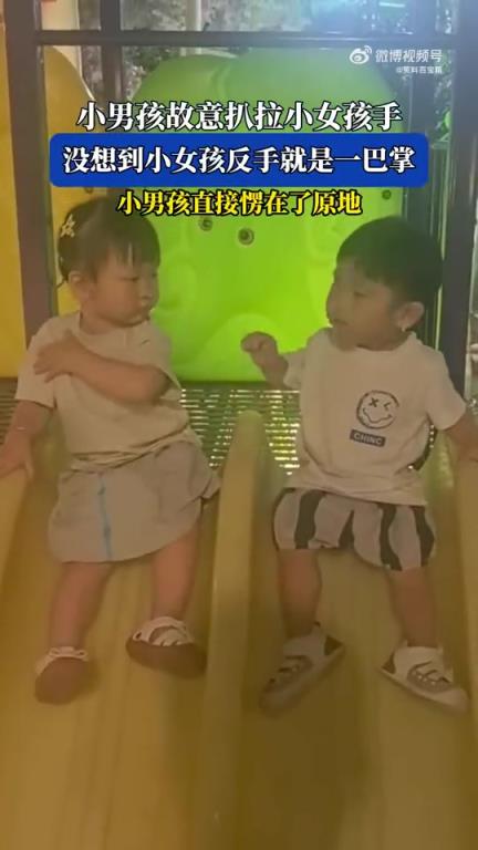 小男孩故意扒拉小女孩手，随后直接愣在原地