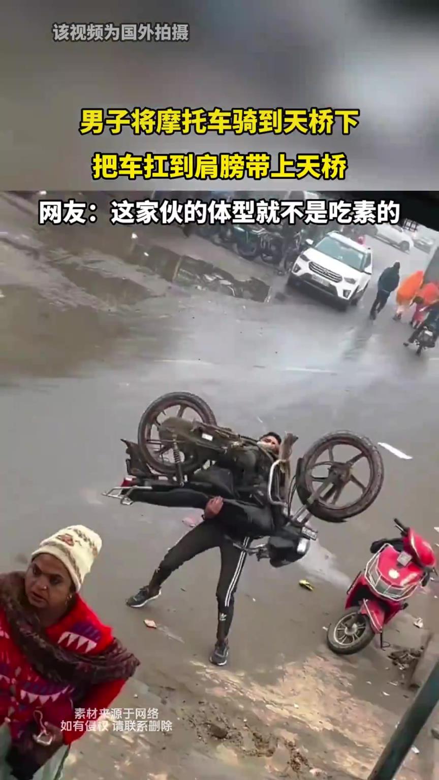 男子将摩托车骑到天桥下，把车扛到肩膀带上天桥