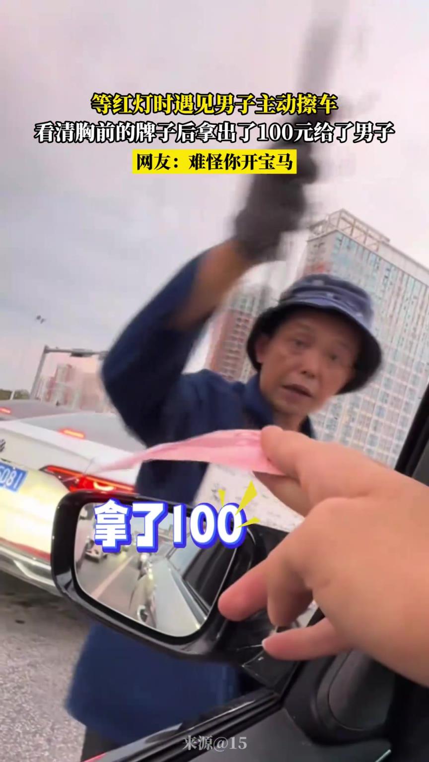 等红灯时遇见男子主动擦车，看清胸前的牌子后拿出了100元给他