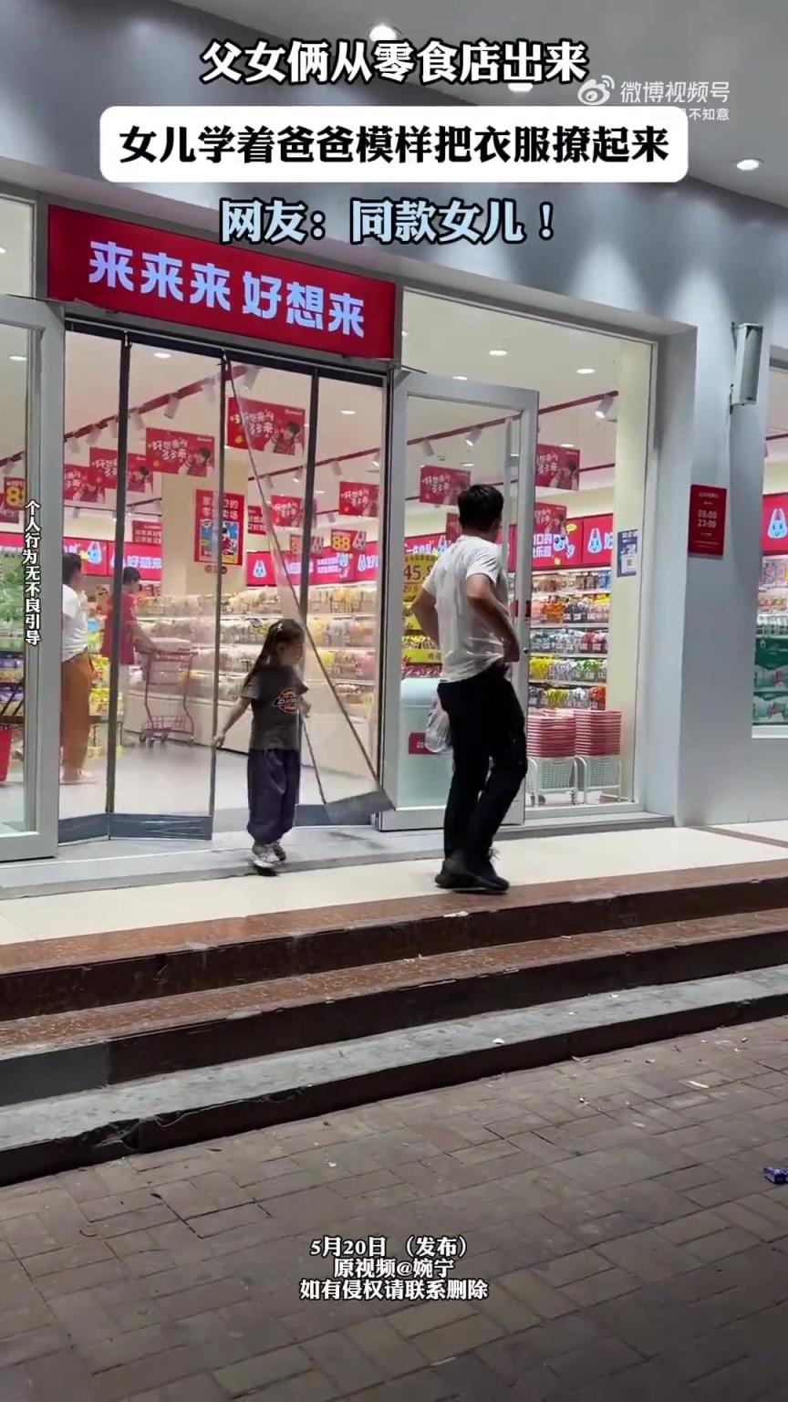 父女走出零食店，女兒模仿爸爸撩起衣服
