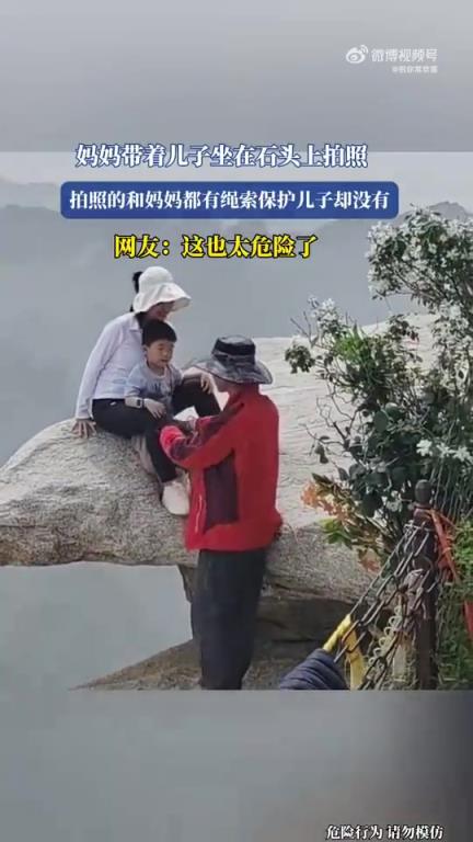 妈妈带着儿子坐在石头上拍照！！