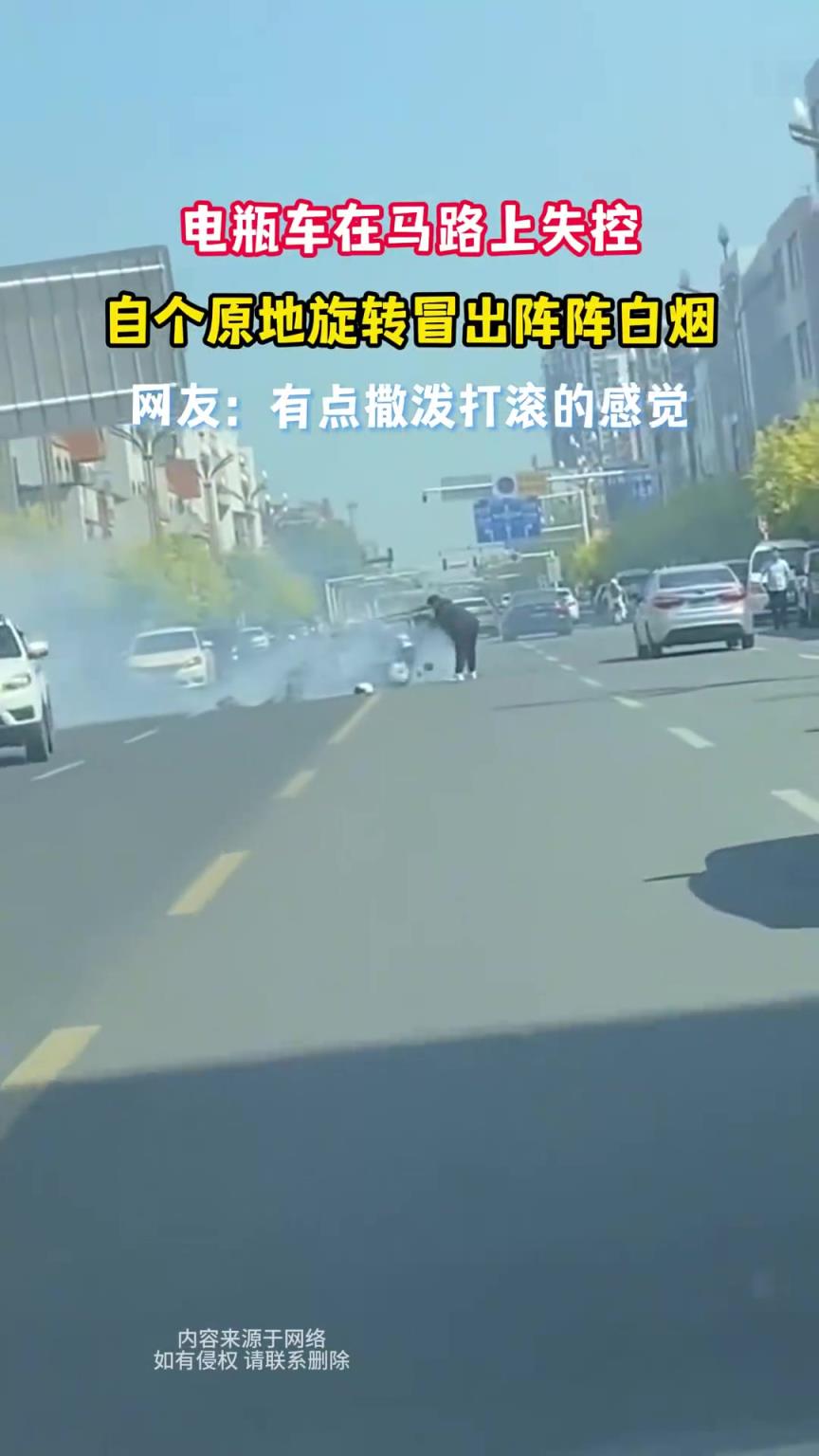 电瓶车在马路上失控，自个原地旋转冒出阵阵白烟