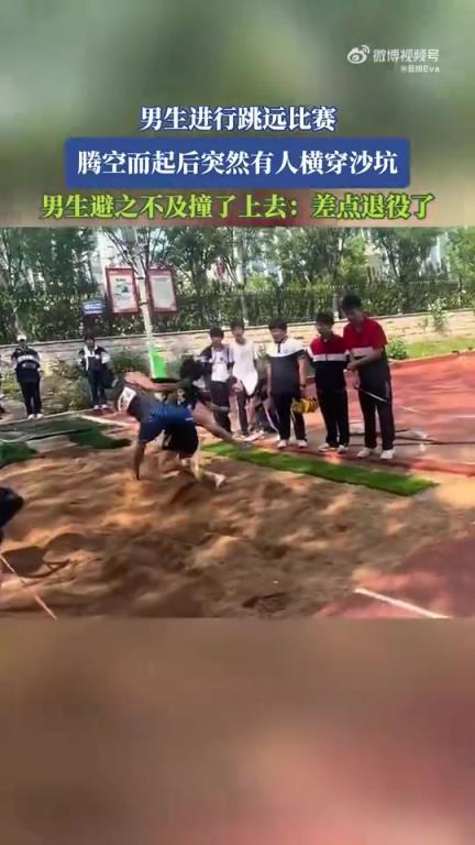 男生跳远时腾空，突遇他人横穿沙坑避撞瞬间