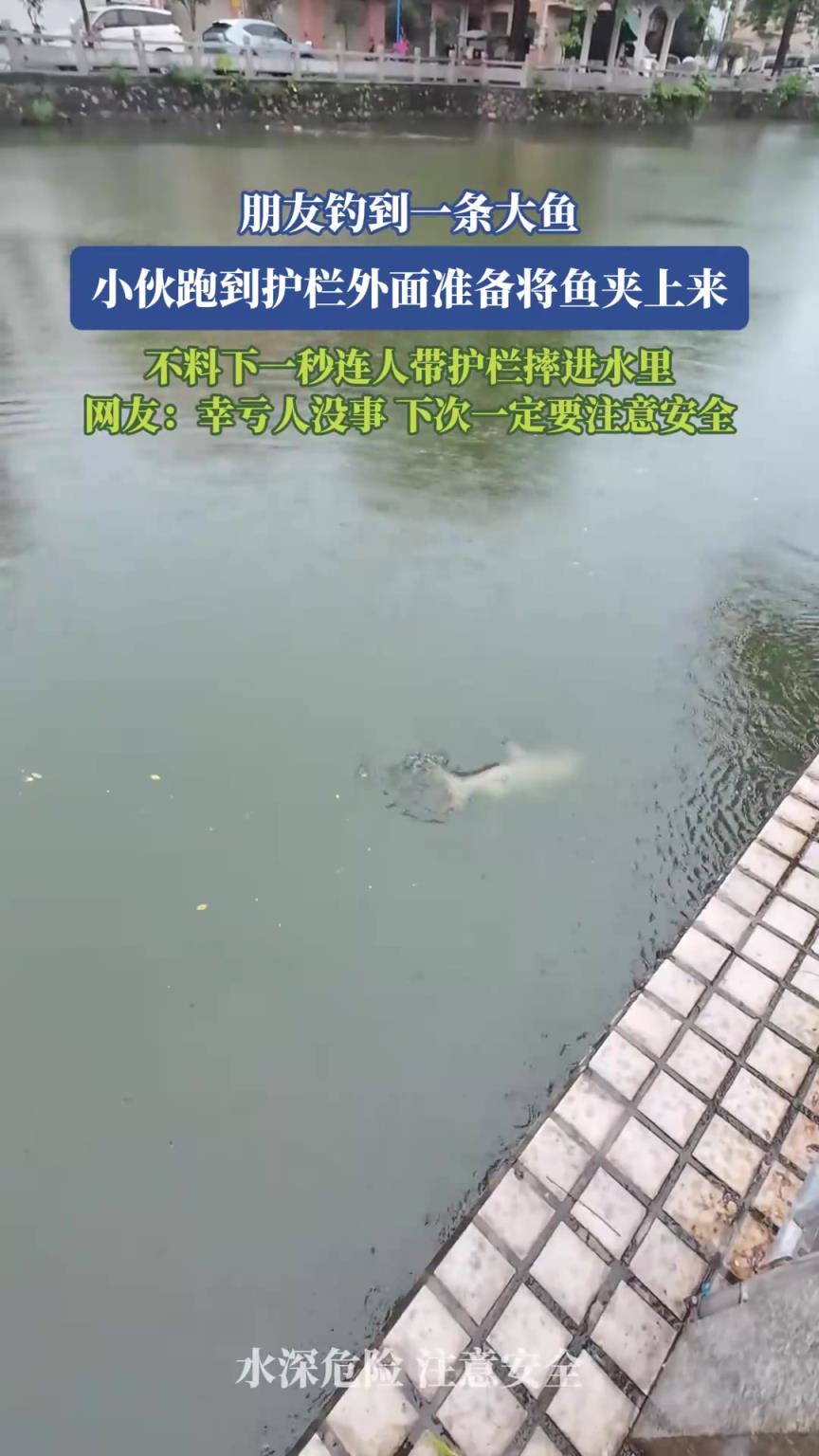 朋友钓到一条大鱼，小伙跑到护栏外面准备将鱼夹上来